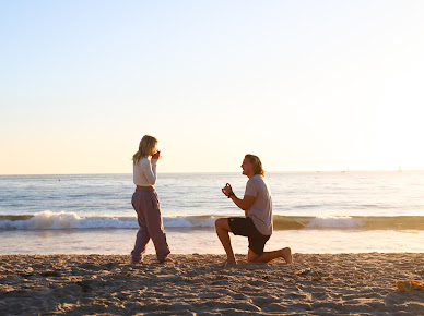 Couple wading in ocean at golden hour